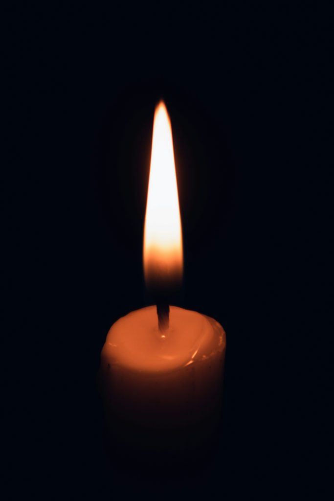 Candlelight in darkness symbolizing awareness as the first step.