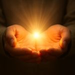 Open hands holding light, symbolizing release and healing through forgiveness